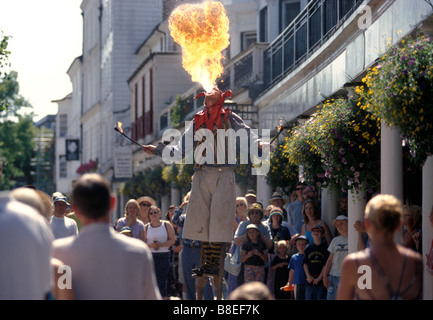 Eine männliche Feuerschlucker auf Stelzen unterhält eine Menschenmenge an der Pantiles. Tunbridge Wells. Kent. England. UK Stockfoto