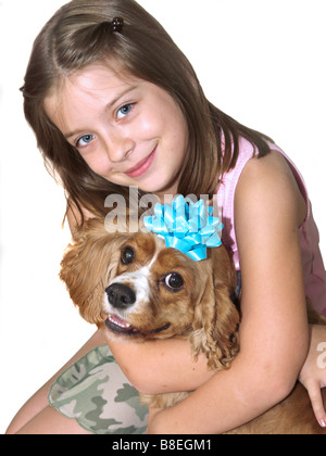 ein kleines Mädchen umarmt ihr Spaniel Hund isoliert Stockfoto