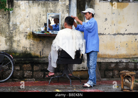 Freiem Himmel Haarschnitt in Vietnam - Friseur und Kunde in der Straße von Nha Trang, Vietnam Stockfoto