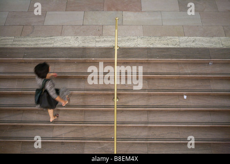 Junge Frau, die zu Fuß die Treppe hinauf Stockfoto