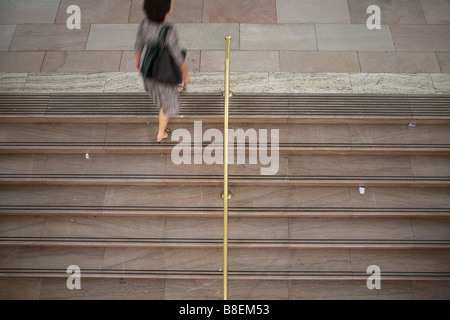 Junge Frau, die zu Fuß die Treppe hinauf Stockfoto