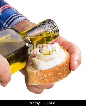 Olivenöl wird auf eine Scheibe Brot gegossen Stockfoto