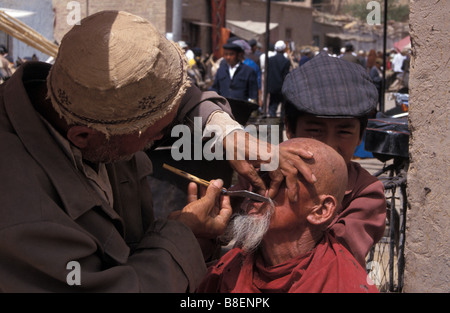 Uigurische Barbier im Basar Sonntagsmarkt von Kashgar Xinjiang China Stockfoto