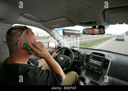 Fahrer sprechen auf einem Handy während der Fahrt auf der Autobahn Stockfoto
