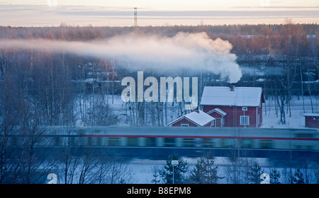 Luftaufnahme von Pkw Zug passiert ein Holz- Einfamilienhaus an sehr kalten Morgen Winter, Oulu, Finnland Stockfoto