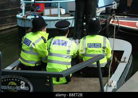 Drei Polizisten in einem Boot und ein paar Beine Stockfoto