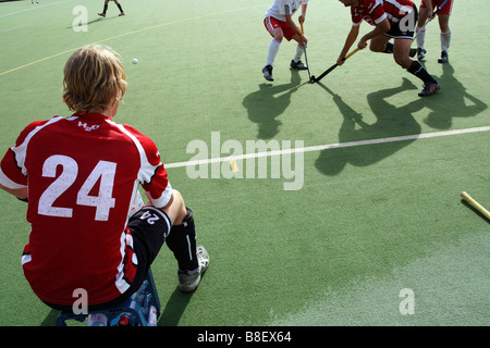 Ein deutscher Hockeyspieler auf einer Bank sitzen und beobachten das Spiel, Rüsselsheim, Deutschland Stockfoto