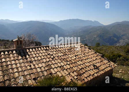 Blick über Dach & Schornstein zu fernen Bergen, in der Nähe von Benimaurell, Vall de Laguar, Provinz Alicante, Comunidad Valenciana, Spanien Stockfoto