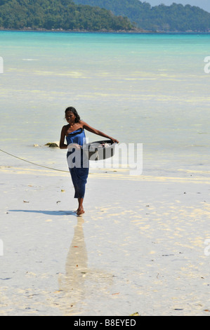 Moken Frau mit ihrem Kunststoff Korb aus Wäsche im Meer, Surin Island, Phangnga, Süd-Thailand. Stockfoto