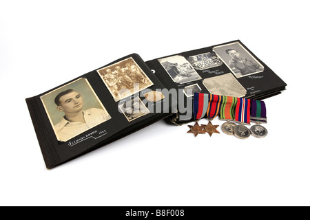 Ein ww2 Veteran s Photo Album mit einer Gruppe von Medaillen vor einem weißen Hintergrund Stockfoto