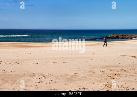 Einsamer Wanderer zu Fuß auf den isolierten uk Strand von Sandwood Bay in Schottland Stockfoto