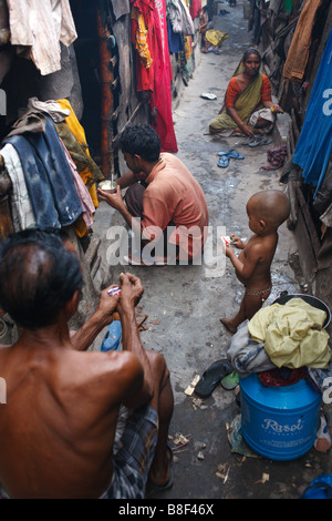 Alltag in einer Gasse mit Kindern und Familien in einem der Slums in Kolkata, Indien Stockfoto