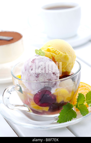 Taro und Mango Eisportionierer im Wasserglas mit Früchten und garnieren Stockfoto