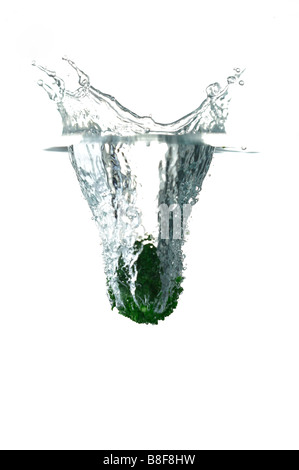 Grüne Zitrone in Wasser spritzt Wasser nach oben zu fallen Stockfoto