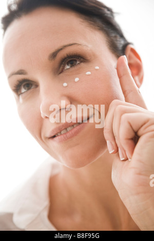 Frau Augencreme anwenden Stockfoto