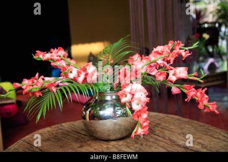 Nahaufnahme von bunten roten Blumen im Gesteck in Silber Vase auf Tisch Stockfoto