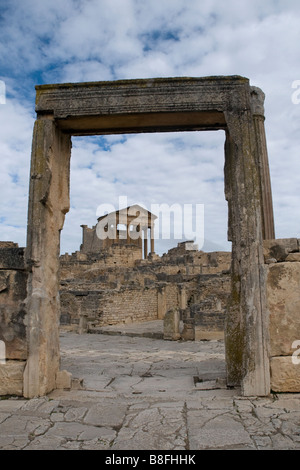 Das Capitol, eine erstklassige Funktion Tunesiens römische Stadt Dougga, betrachtet durch einen Bogen bergab Stockfoto