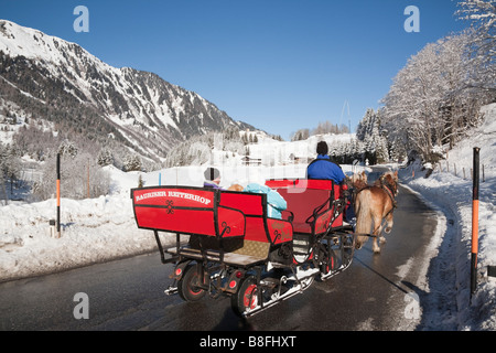 Touristen auf Pferd gezogenen Schlitten fahren Sie durch Alpental im Winterschnee. Bucheben Rauriser Tal Austria Stockfoto