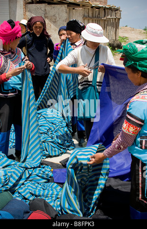 Asien, China, Yunnan Provinz, Yuanyang. Hani und Yi Frauen kaufen Meterware auf dem Dorfmarkt Shengcun. Stockfoto