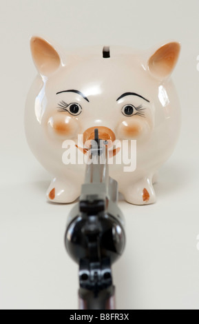 Sparschwein mit einer Pistole auf sie gerichtet Stockfoto