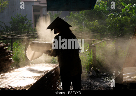 Frau mit der traditionellen konische Hut machen Reispapier. Mekong-Delta, Vietnam Stockfoto