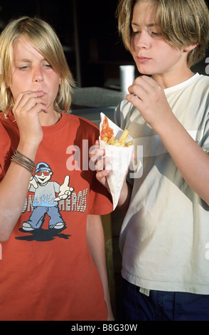 Zwei jungen Essen Chips aus ein wenig Paperbag - Takeaway - Ernährung - Jugend Stockfoto