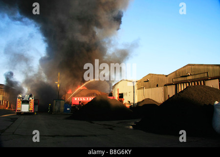 Eine Spalte mit dichter Rauch steigt aus einem Feuer der brennenden Reifen oder Reifen Stockfoto