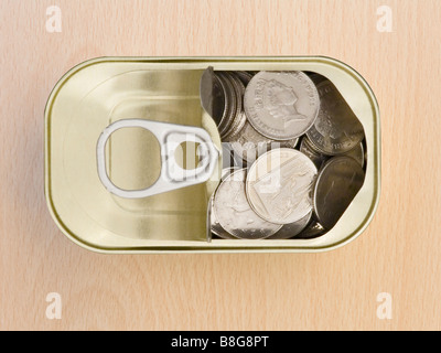 Ring ziehen Blechdose mit 10 Pence Stücke auf einem Holz- Oberfläche Stockfoto