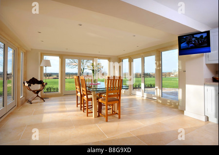 EIN ESSZIMMER UMGEBEN VON TERRASSENTÜREN IN EIN MODERNES LANDHAUS-UK Stockfoto