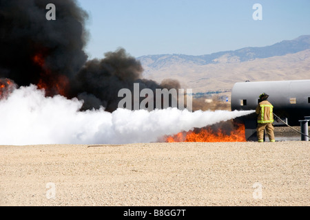 Feuerwehrmann mit feuerhemmenden Schaumstoff, ein Jet Fuel Feuer an einem Flughafen Schulungseinrichtung in Boise, Idaho USA Stockfoto