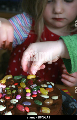 Kinder, die einen Kuchen dekorieren Stockfoto