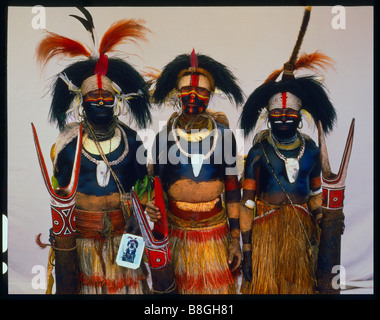 Drei Männer von Pimaga Dorf in der Nähe von Mendi im südlichen Hochland von Papua-Neu-Guinea mit einer holding eine Polaroid drucken Stockfoto