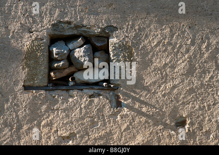 Alte Scheune Fenster blockiert mit Steinen, Frankreich. Stockfoto
