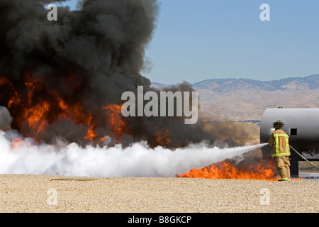 Feuerwehrmann mit feuerhemmenden Schaumstoff, ein Jet Fuel Feuer an einem Flughafen Schulungseinrichtung in Boise, Idaho USA Stockfoto