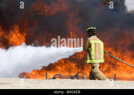 Feuerwehrmann mit feuerhemmenden Schaumstoff, ein Jet Fuel Feuer an einem Flughafen Schulungseinrichtung in Boise, Idaho USA Stockfoto