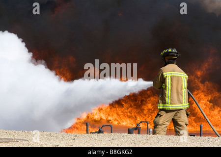 Feuerwehrmann mit feuerhemmenden Schaumstoff, ein Jet Fuel Feuer an einem Flughafen Schulungseinrichtung in Boise, Idaho USA Stockfoto