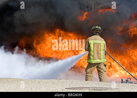 Feuerwehrmann mit feuerhemmenden Schaumstoff, ein Jet Fuel Feuer an einem Flughafen Schulungseinrichtung in Boise, Idaho USA Stockfoto