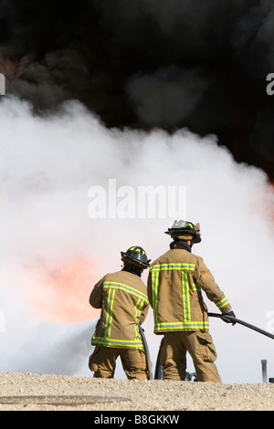 Feuerwehrleute mit feuerhemmenden Schaumstoff, ein Jet-Fuel löschte Feuer an einem Flughafen Schulungseinrichtung in Boise, Idaho USA Stockfoto