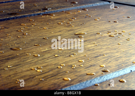 Nahaufnahme von Wassertropfen auf Holzuntergrund Stockfoto