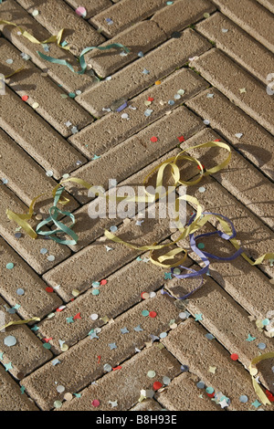 viele bunte Konfetti und Girlanden auf asphaltierten Straße Straße in Sonne Stockfoto