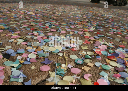 viele bunte Konfetti und Girlanden auf asphaltierten Straße Straße in Sonne Stockfoto