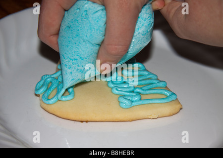 Frau icing Sugar Cookies geformt wie ein Herz zum Valentinstag Stockfoto