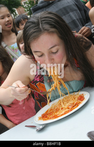 Kinder teilnehmen an eine Spaghetti Wettessen Stockfoto