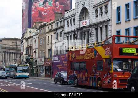 Touristen Sightseeing Bus in Lime St Liverpool mit großen FC Liverpool Werbetafel und der alten Futuristischen Kino im Hintergrund Stockfoto