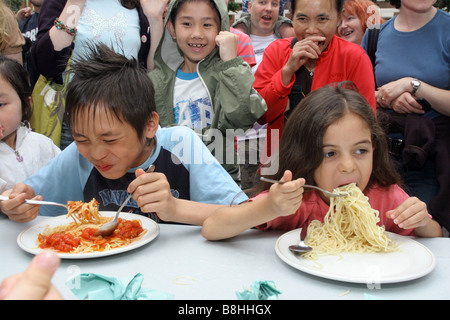 Kinder teilnehmen an eine Spaghetti Wettessen Stockfoto
