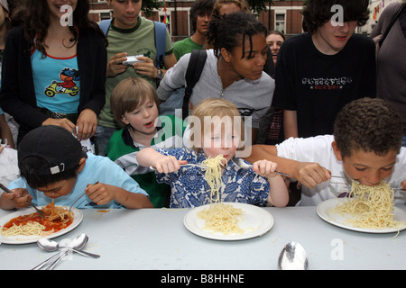 Kinder teilnehmen an eine Spaghetti Wettessen Stockfoto