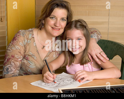 Sonntagsschullehrer und kleine Mädchen malen ein Bild von Jesus Stockfoto