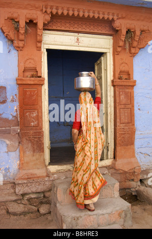 Frau mit Wasser ins Haus, "Blaue Stadt" in Jodhpur, Rajasthan, Indien Stockfoto