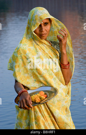 Frau trägt Sari, stehend im Fluss mit Ringelblume anbieten, Agra, Indien Stockfoto