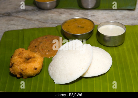 Indien-Tamil Nadu südindische Frühstück, zwei Iddlies mit Sambar Chutney und Vadai mit Zwiebel-Chutney auf Banane Blatt Teller serviert Stockfoto